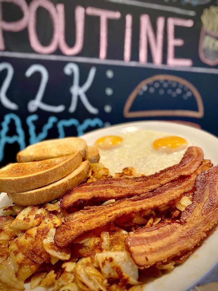 Two eggs sunny side up with crisp bacon, hashbrowns and toast on a Sammy's plate